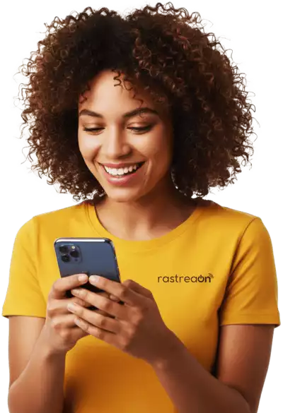 Mulher morena e sorridente com a camisa RastreaOn, utilizando o celular para fazer o Rastreamento Veicular em tempo real pelo Aplicativo, demonstrando a facilidade do Rastreamento móvel.